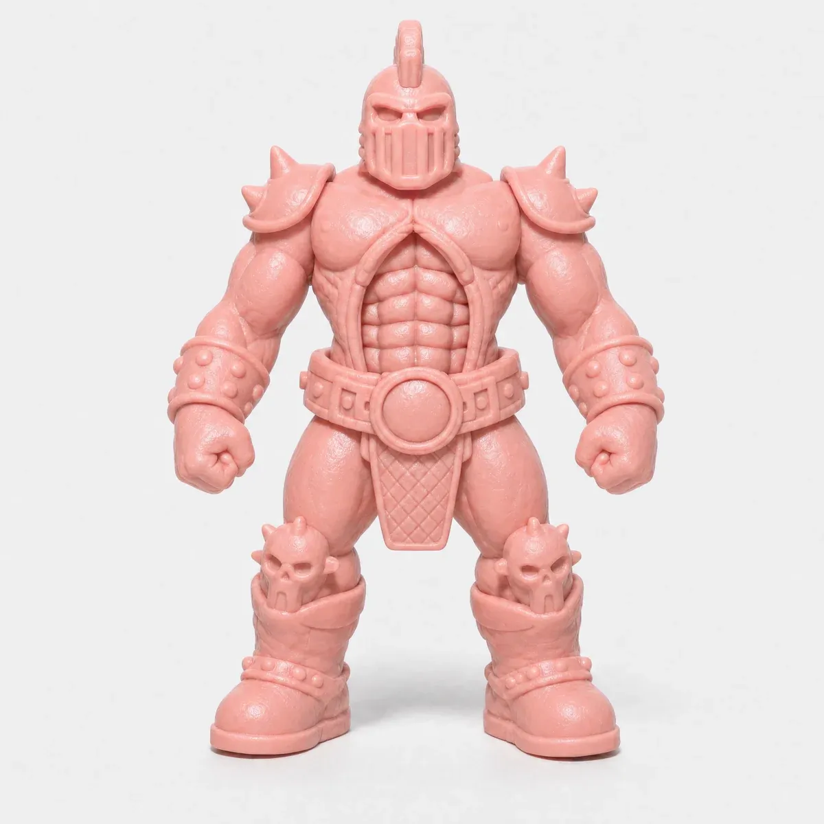A pink toy figure of a helmeted wrestler with a mohawk crest and a chunky belt buckle.