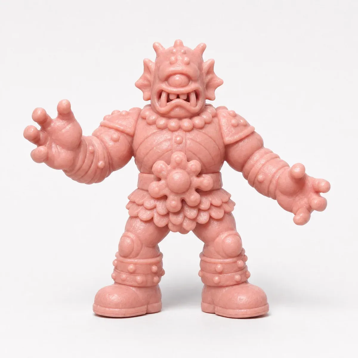 The pink cyclops figure from the front, arms out, on a light gray ground.